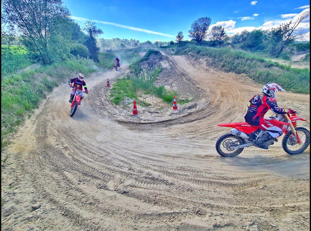 Jugend Motocross Training: Fahrer auf Honda Motocross Motorrädern beim Kurventraining zwischen Pylonen