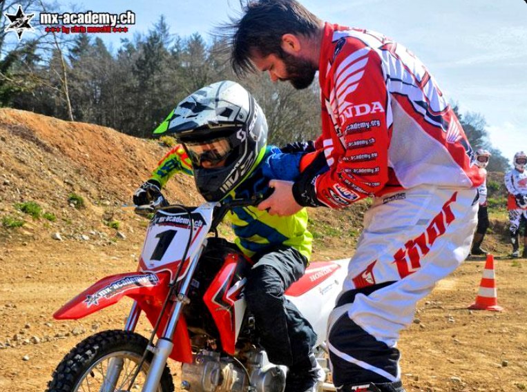 Motocross für Jugendliche: Ein Trainer begleitet den Nachwuchsfahrer mit Startnummer 1 auf der Honda CRF beim Anfahren