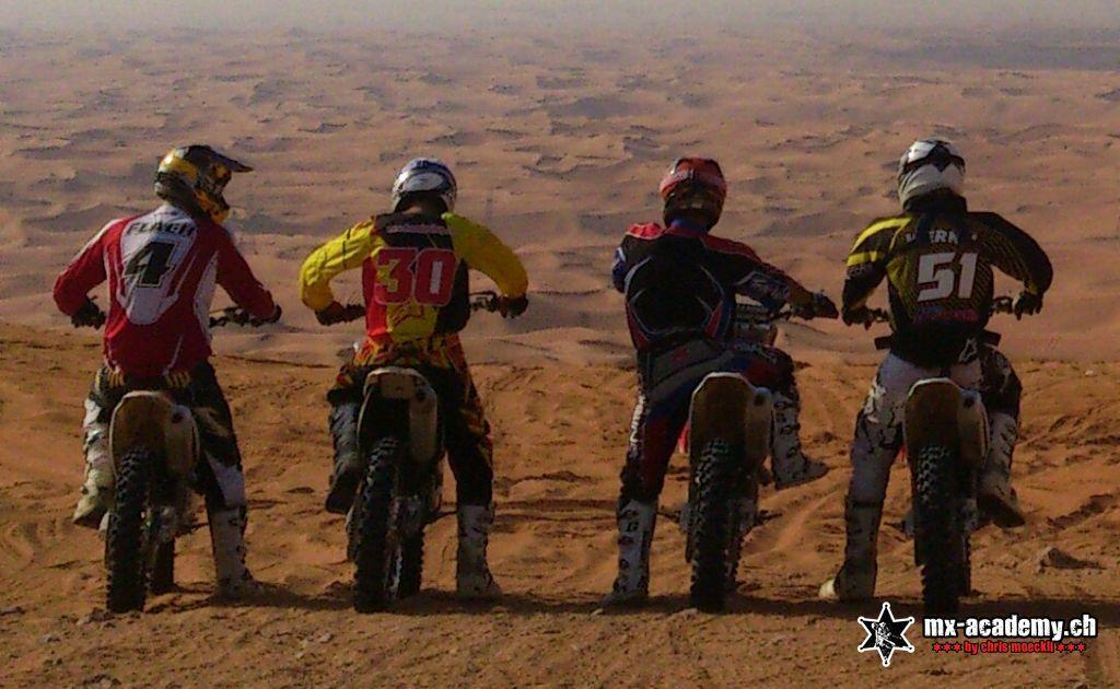 Motocross Gruppe blickt über die Dünen von Dubai