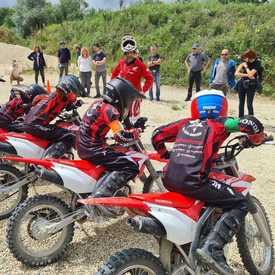 Motocross pour jeunes en Suisse : des jeunes sur des motos de cross Honda écoutent le moniteur lors d’un cours de groupe à la MX-Academy